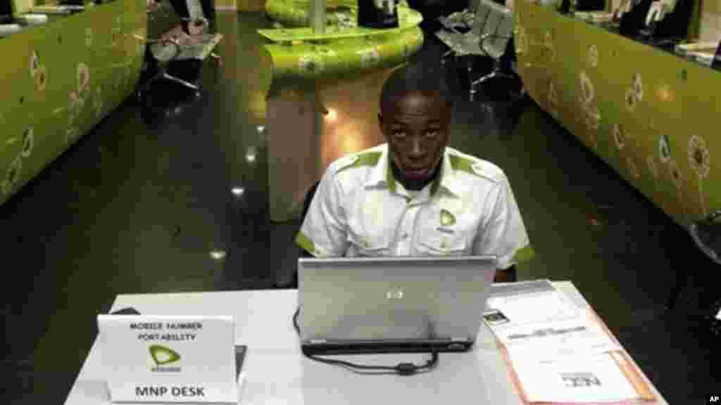 In this photo taken on an iphone, a staff member of Etisalat Nigeria waits for customers, during the launch of mobile number portability in Lagos, Nigeria, Monday, April 22, 2013.