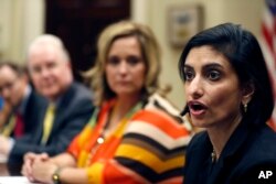 FILE - Dr. Douglas Lake, from Iowa, left, Health and Human Services Secretary Tom Price, Candace Fowler, from Missouri, listen as Seema Verma, Administrator of the Centers for Medicare and Medicaid Services, speaks during a listening session in the White House, June 21, 2017.
