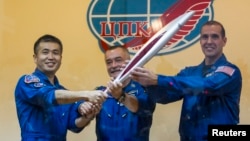 Phi hành gia Nhật Bản Koichi Wakata, nhà du hành vũ trụ Nga Mikhail Tyurin, và phi hành gia Mỹ Rick Mastracchio, chụp ảnh cùng với ngọn đuốc Olympic 2014 