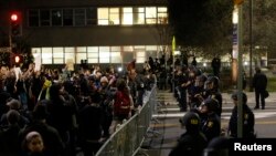 Protesters chant in front of a police line outside Berkley Police Department headquarters during a march against the New York City grand jury decision to not indict in the death of Eric Garner in Berkeley, California, Dec. 9, 2014.