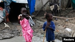 Children walk through mud in an internally displaced persons camp inside the United Nations base in Malakal, South Sudan, July 23, 2014.