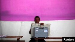 Seorang petugas TPS memegang mesin pemilihan elektronik di distrik Jorhat, negara bagian Assam (6/4). (Reuters/Adnan Abidi)