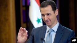 FILE - In this Feb. 10, 2015 photo released by the Syrian official news agency SANA, Syrian President Bashar Assad gestures during an interview with the BBC, in Damascus.