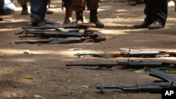 FILE - Guns are seen on the ground in Yambio, South Sudan, Feb. 7, 2018. Nine people — including eight humanitarian workers — abducted Monday outside the Equatorian town of Yambio have been freed.