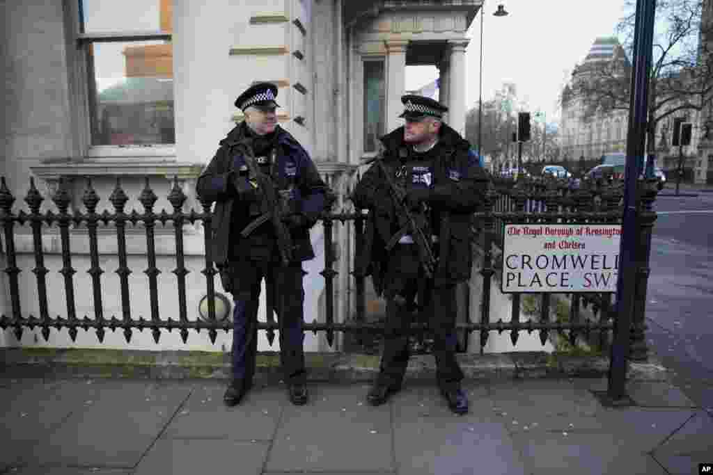 Armed British police officers stand on guard near the French Institute and French School in the South Kensington area of London, on the same day the new edition of French satirical weekly paper Charlie Hebdo went on sale in France, Jan. 14, 2015.