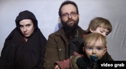 FILE - In this still image taken from a December 2016 video released by the Afghan Taliban, U.S. national Caitlan Coleman and her Canadian husband, Joshua Boyle, read a statement urging then-President-elect Donald Trump to negotiate to secure their release.