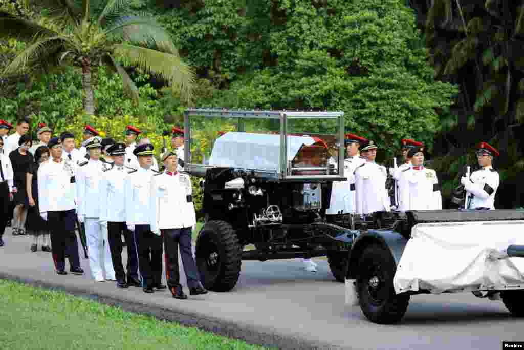 Pasukan Kehormatan mengawal peti jenazah perdana menteri pertama Singapura yang akan dibawa ke Gedung Parlemen tempat ia akan disemayamkan sampai Sabtu di Singapura (25/3).