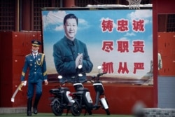 资料照片：在北京紫禁城入口附近，一名仪仗兵走过巨幅习近平宣传标语牌。(2021年9月18日)