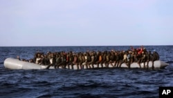 Para migran terlihat berjejal dalam sebuah perahu karet setelah diselamatkan oleh anggota LSM Proaktif Open Arms LSM, di Laut Mediterania, sekitar 22 mil utara dari Zumarah, Libya, 27 Januari, 2017. (AP Photo/Emilio Morenatti)