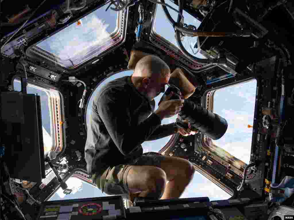 Astronaut NASA-e, američke agencije za istraživanje svemira pokušava fotoapratom sa teleobjektivom od 400 milimetara snimiti nesto na Zemlji, 250 milja (oko 400 kilometara) udaljenoj od Međunarodne svemirske stanice. 