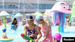 FILE - Visitors cool off at Munsu Water Park east of Pyongyang, North Korea — a project in which wealthy individuals known as Donju are said to have played a key role.