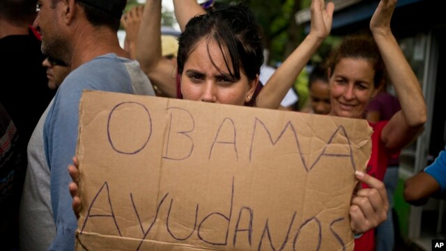 Una migrante cubana varada en Costa Rica muestra un cartel pidiendo ayuda al presidente de EE.UU. durante una protesta en noviembre de 2015. Países centroamericanos aprobaron un plan para ayudar a los migrantes a llegar a EE.UU. por vía aérea y terrestre.
