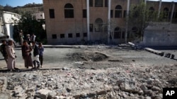 FILE - Shiite fighters, known as Houthis, gather at the site of a Saudi-led coalition airstrike in Sanaa, Yemen, Friday, Oct. 16, 2015. 