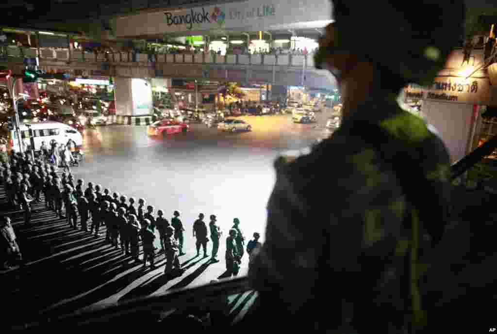  Thai soldiers secure an intersection in downtown Bangkok to prevent pro-government demonstrators from gathering to protest against the coup. 