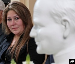 Costa Rica's Floribeth Mora looks at a bust of Pope John Paul II while giving her account of a miracle attributed to John Paul, during a press conference at the Archbishop's office in San Jose, Costa Rica, July 5, 2013.