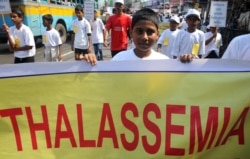 Seorang anak sekolah India memegang poster saat dia ikut serta dalam demonstrasi untuk meningkatkan kesadaran kondisi Thalassaemia di Kolkata pada 8 Mei 2012, pada Hari Thalassaemia Internasional. (Foto: AFP/Dibyangshu Sarkar)