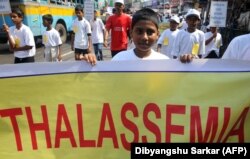 Seorang anak sekolah India memegang poster saat dia ikut serta dalam demonstrasi untuk meningkatkan kesadaran kondisi Thalassaemia di Kolkata pada 8 Mei 2012, pada Hari Thalassaemia Internasional. (Foto: AFP/Dibyangshu Sarkar)