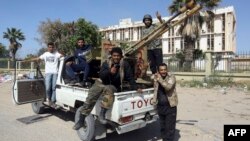 Forces loyal to Libya's Government of National Accord gesture, April 18, 2019, after taking control of the area of al-Aziziyah, located about 40 kilometers south of the Libyan capital Tripoli, following fierce clashes with forces loyal to strongman Khalifa Haftar.