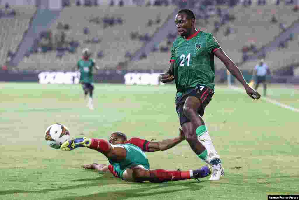 Morocco&#39;s forward Ayoub Kaabi (L) fights for the ball with Malawi&#39;s defender Gomezgani Chirwa during in Cameroon, Jan. 25, 2022.