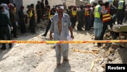 Một người đàn ông bị thương bước đi trong khi các nhân viên cứu hộ đang tìm kiếm sau vụ nổ gần nhà Bộ trưởng Bộ Nội vụ Shuja Khanzada ở Attock, Pakistan, 16/8/2015.