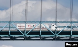 A commercial truck with a Canada, United States and Mexico flag on its side is seen crossing over the Ambassador Bridge into Windsor, Ontario from Detroit, Michigan, Aug. 29, 2018.