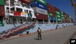 FILE - A Pakistan Navy soldier stands guard while a loaded Chinese ship prepares to depart, at Gwadar port, about 700 kilometers (435 miles) west of Karachi, Pakistan, Nov. 13, 2016.