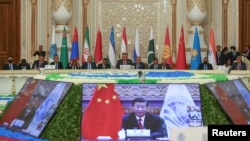 Participants listen to China's President Xi Jinping speaking via a video link during the Shanghai Cooperation Organization (SCO) summit in Dushanbe, Tajikistan, Sept. 17, 2021.