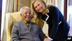 La secretaria de Estado de EE.UU, Hillary Clinton, y el ex residente Mandela posan sonrientes para los fotógrafos.