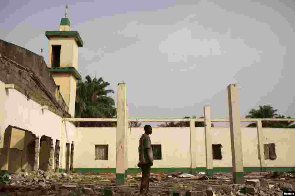 Seorang pria berdiri di atas puing-puing masjid yang dihancurkan dalam kekerasan sektarian di Miskine, Bangui (5/3).