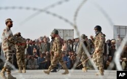 FILE - People wait to cross into Afghanistan at the Pakistani border post Chaman, Sept. 1, 2016. A recent spate of cross-border terrorist attacks have resulted in renewed restrictions on the frontier between the two countries.