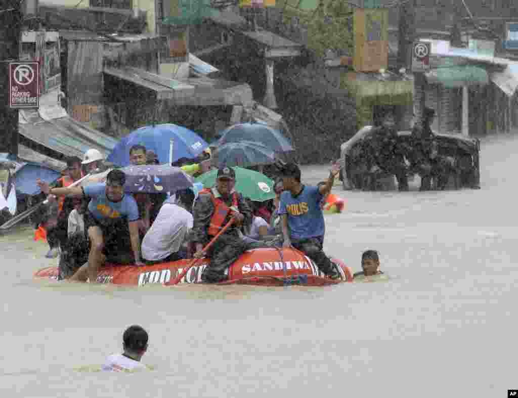 Lực lượng cứu hộ sử dụng thuyền cao su giải cứu người dân bị mắc kẹt sau khi trận mưa do gió mùa nặng, gây nên bởi cơn bão nhiệt đới Fung-Wong, làm ngập lụt thành phố Marikina, phía đông Manila, Philippines và hầu hết các nơi trong đô thị. 