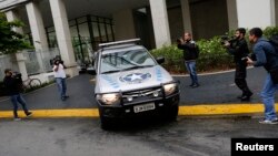 Members of the media record as a vehicle belonging to the Brazilian Federal Revenue Authority (RFP) leave the headquarters of Brazilian conglomerate Camargo Correa during "Operation Car Wash" in Sao Paulo, Nov. 14, 2014. 