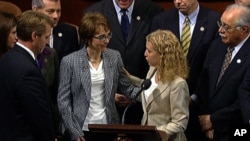 This video image provided by House Television shows Rep. Gabrielle Giffords, D-Ariz., accompanied by Democratic National Committee Chair Rep. Debbie Wasserman Schultz, D-Fla., walks on the floor of the House on Capitol Hill in Washington, Wednesday, Jan.