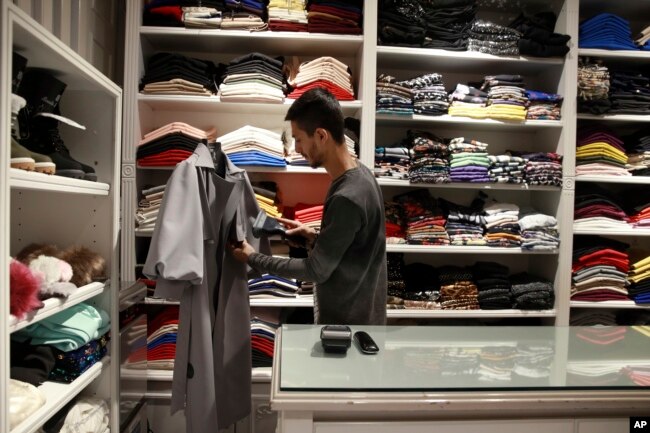 A shopkeeper adjusts a dress in a shop at the Kourosh shopping mall, in Tehran, Iran, Feb. 6, 2019.