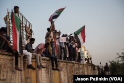 Protesters chant and wave Sudanese flags as dusk approaches on the first day of Ramadan May 6, 2019, at the sit-in in Khartoum, Sudan.