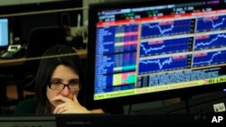 A broker works in a trading room of a Portuguese bank in Lisbon, Wednesday, July 3, 2013.