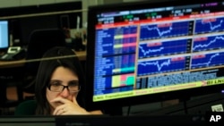 A broker works in a trading room of a Portuguese bank in Lisbon, Wednesday, July 3, 2013.
