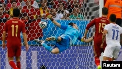 Spain's goalkeeper Iker Casillas dives trying to save a ball from Chile's Charles Aranguiz (not pictured) during their 2014 World Cup Group B soccer match at the Maracana stadium in Rio de Janeiro, June 18, 2014.