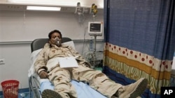 In this photo taken on a government organized tour, a Libyan soldier wearing oxygen mask lies at Khadra Hospital in Tripoli, Libya following an air strike, May 12, 2011