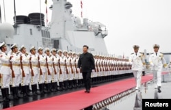 Chinese President Xi Jinping reviews the honor guards of the Chinese People’s Liberation (PLA) Navy before boarding the destroyer Xining for the naval parade celebrating the 70th founding anniversary of the Chinese People's Liberation Army (PLA) Navy.