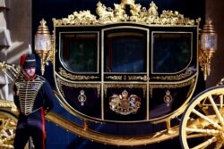 Seorang anggota Pasukan Raja berdiri di samping Kereta Jubilee di halaman Royal Mews di Istana Buckingham di London, Inggris, 21 September 2021. (Foto: REUTERS/Hannah McKay)