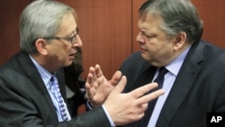 Luxembourg's Prime Minister and Eurogroup chairman, Jean-Claude Juncker (L) talks with Greece's Finance Minister Evangelos Venizelos at the start of a Eurogroup meeting at the European Union council headquarters in Brussels, February 9, 2012.