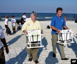 US state and federal wildlife officials Nick Wiley (left) and Tom Strickland carry custom containers with sea turtle eggs to FedEx trucks for delivery to Canaveral National Seashore.