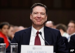 FILE - Former FBI Director James Comey smiles during a Senate Intelligence Committee hearing on Capitol Hill, in Washington, June 8, 2017.