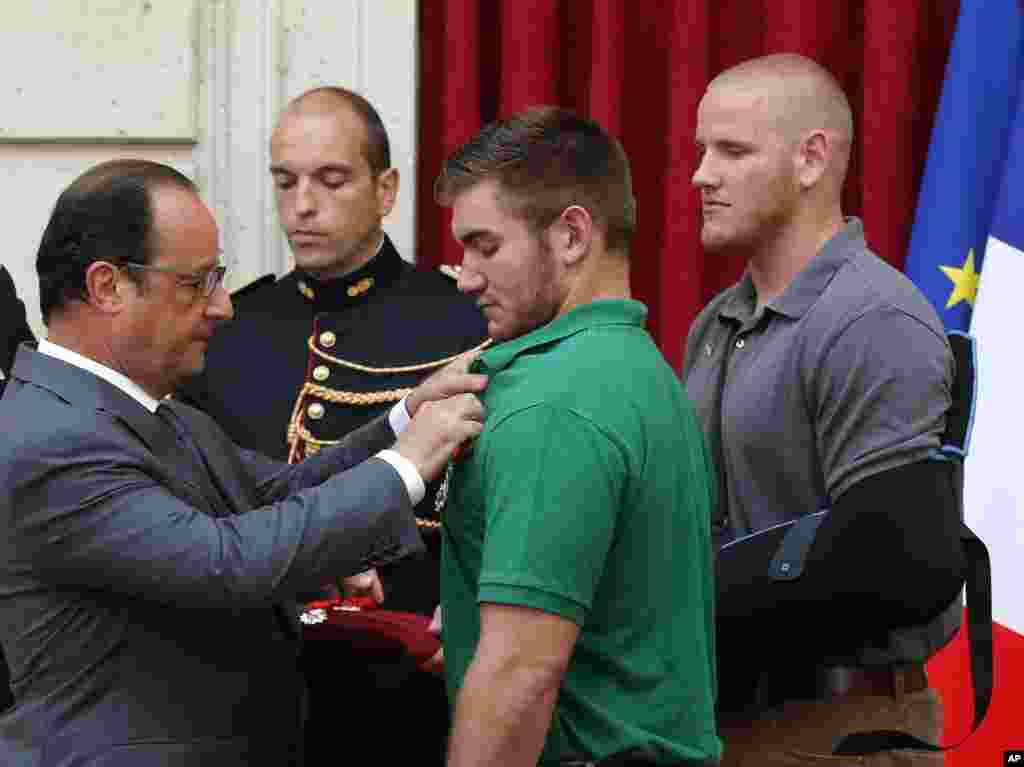French President Francois Hollande bestows the Legion of Honor upon Alek Skarlatos, a U.S. National Guardsman from Roseburg, Oregon, while U.S. Airman Spencer Stone looks on at the Elysee Palace,&nbsp; in Paris, Aug. 24, 2015.