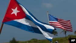 FILE - U.S. and Cuban flags fly. The countries re-established diplomatic relations earlier this year following a half century of estrangement.