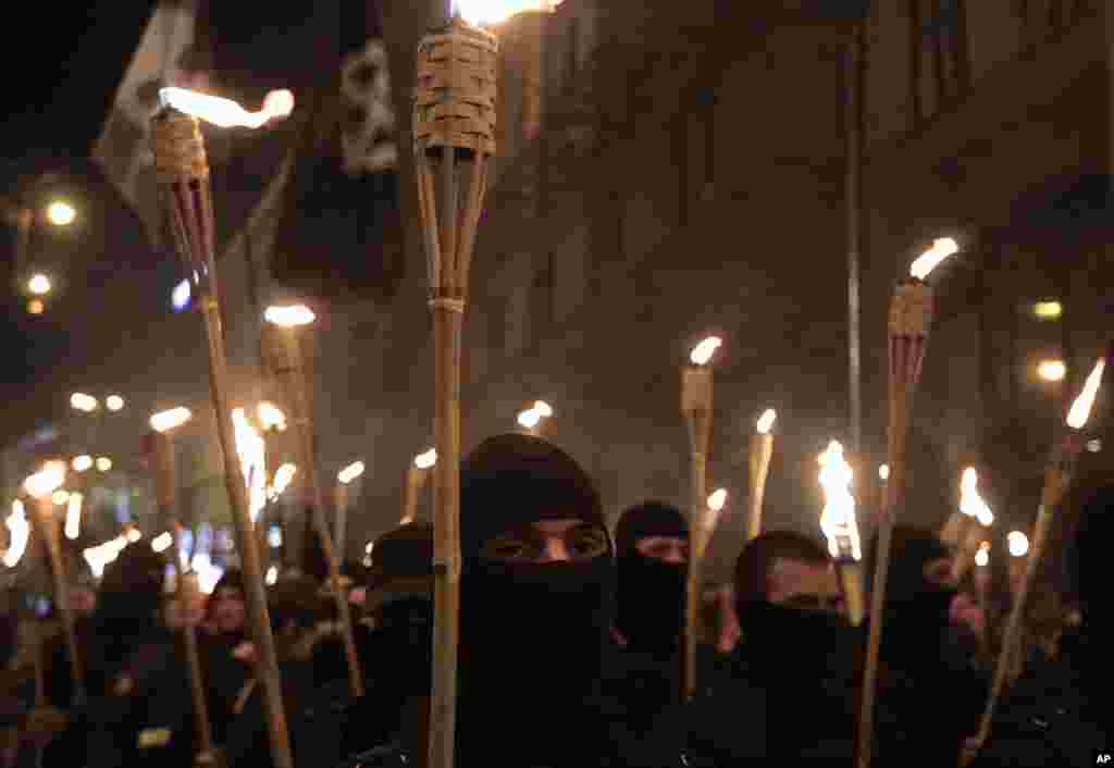 With their faces covered and carrying burning torches, Ukrainian nationalists attempt to march to Kyiv's Independence Square to honor the protesters who were killed in February clashes with police, April 29, 2014.