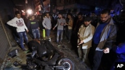 People gather near the site of a twin suicide attack in Burj al-Barajneh, southern Beirut, Lebanon, Thursday, Nov. 12, 2015 that struck a Shiite suburb.