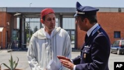 In this photo taken June 23, 2017, Imam Mimoun El Hachmi, left, talks to Italian penitentiary Police Commander Fabio Gallo inside the Terni penitentiary, Italy.