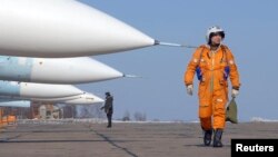 Seorang pilot berjalan melewati pesawat jet tempur SU-27SM di pangkalan militer Rusia di Vladivostok, 14 Februari 2008 (Foto: dok). 